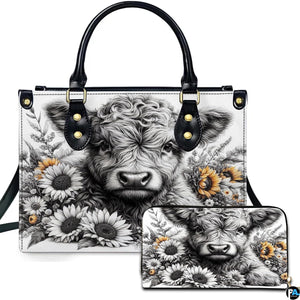 Handbag and matching wallet with baby Highland cow calf and sunflower illustration on a crisp white backdrop.