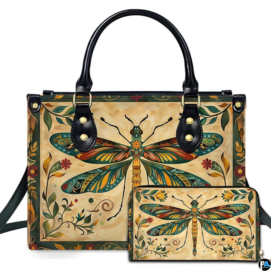 Studio display of vintage folk art dragonfly handbag and matching wallet with botanical border on parchment