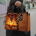 Woman carrying the sunrise cross faith handbag outdoors on a paved street.
