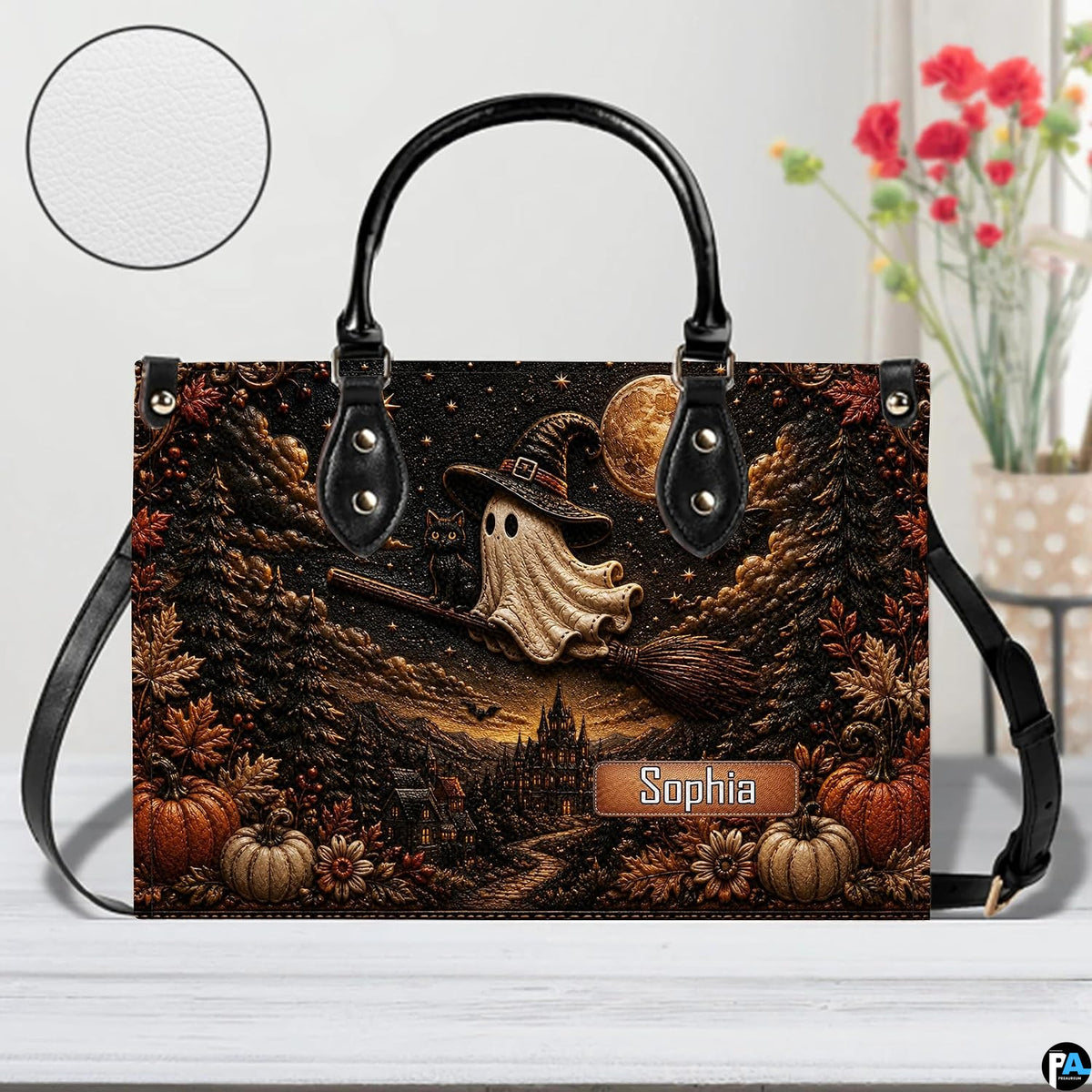 Surface tabletop view of ghost witch graphic satchel positioned next to decorative botanical vase.