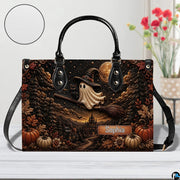 Surface tabletop view of ghost witch graphic satchel positioned next to decorative botanical vase.