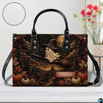 Surface tabletop view of ghost witch graphic satchel positioned next to decorative botanical vase.
