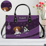 Close-up perspective of illustrated puppy faces, paw print pattern, and decorative badge on handbag.