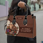 Model carrying golden dragon themed handbag by top handles on an outdoor sidewalk