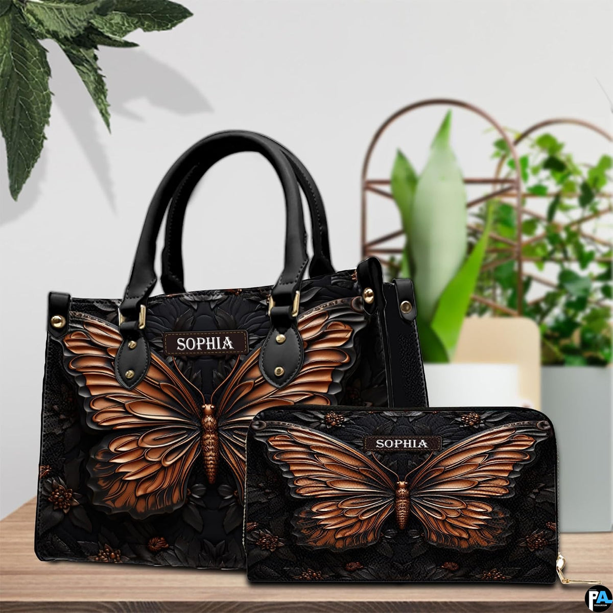 Copper butterfly handbag and matching wallet displayed together on a wooden tabletop near houseplants.
