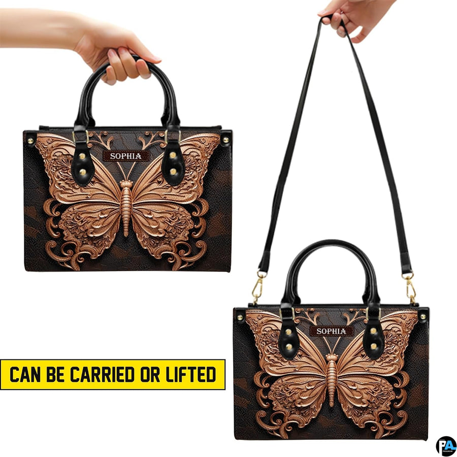 Detailed display of top handles, removable strap attachment, and zipper elements on the butterfly handbag.