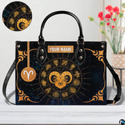Angled perspective view of zodiac ram handbag highlighting radiating gold rays and corner filigree.