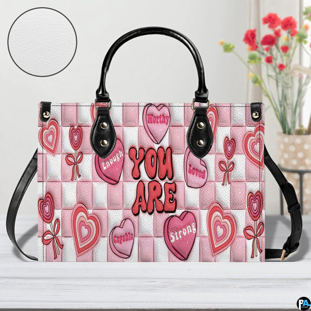 Pink affirmation handbag displayed in studio setting with circular texture swatch inset.