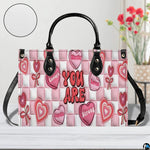 Pink affirmation handbag displayed in studio setting with circular texture swatch inset.