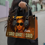 Urban outdoor perspective of model holding the afro queen statement handbag by upper handles.