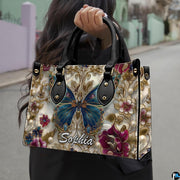 Perspective view of baroque gold butterfly handbag and wallet pair