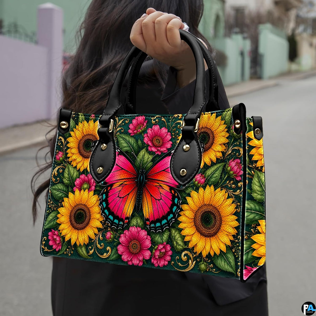Outdoor street view showing pink butterfly and sunflower artwork held by pedestrian along city sidewalk.