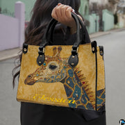 Side profile of ornate giraffe handbag showing structured silhouette and black carrying handles.