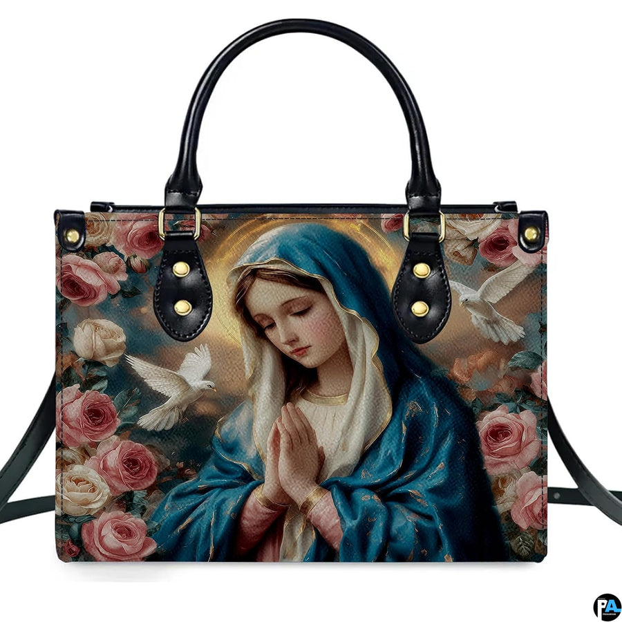 Front isolated view of Virgin Mary praying devotional handbag with rose artwork.