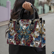 Perspective view of baroque teal butterfly handbag and wallet pair