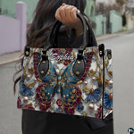 Perspective view of baroque teal butterfly handbag and wallet pair