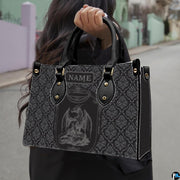 Dragon crest damask handbag carried outdoors by top handle along residential street.