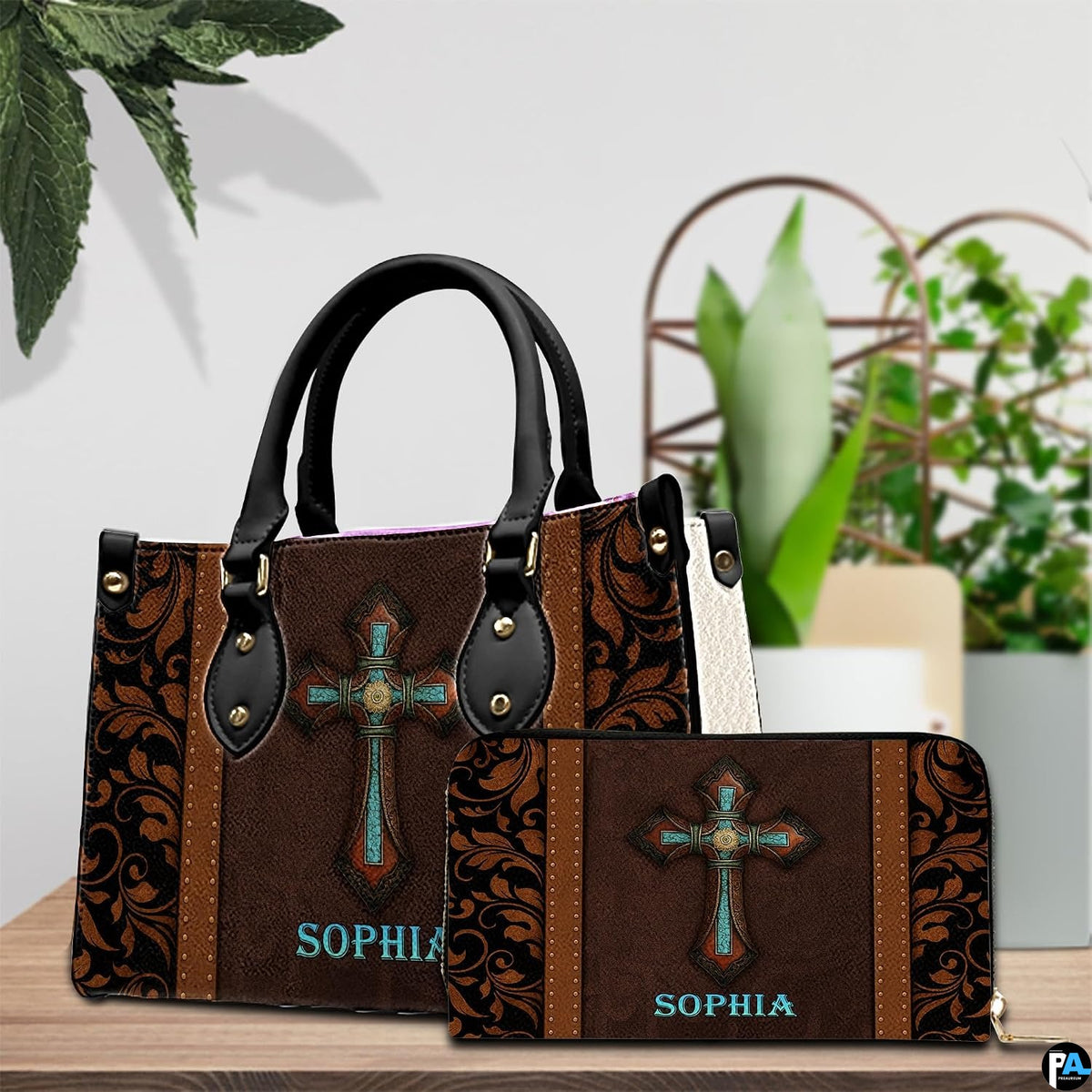 Handbag and coordinating zip wallet set displayed on a wooden surface beside an indoor potted plant.