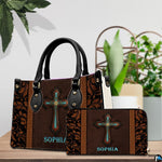 Handbag and coordinating zip wallet set displayed on a wooden surface beside an indoor potted plant.