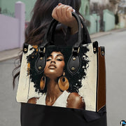 Woman carrying cream and black afro portrait handbag with oversized gold earrings