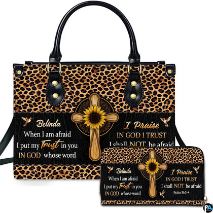 Front view of leopard and sunflower cross handbag and matching wallet with wooden cross centerpiece and hummingbirds.