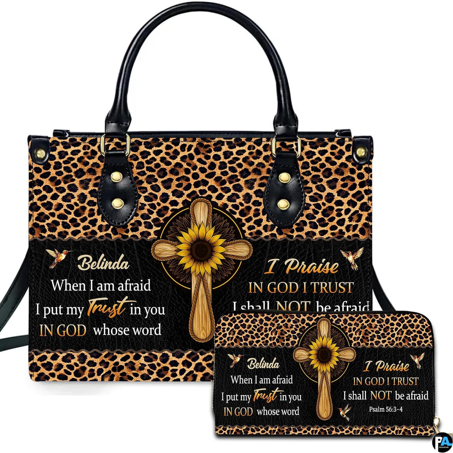 Front view of leopard and sunflower cross handbag and matching wallet with wooden cross centerpiece and hummingbirds.