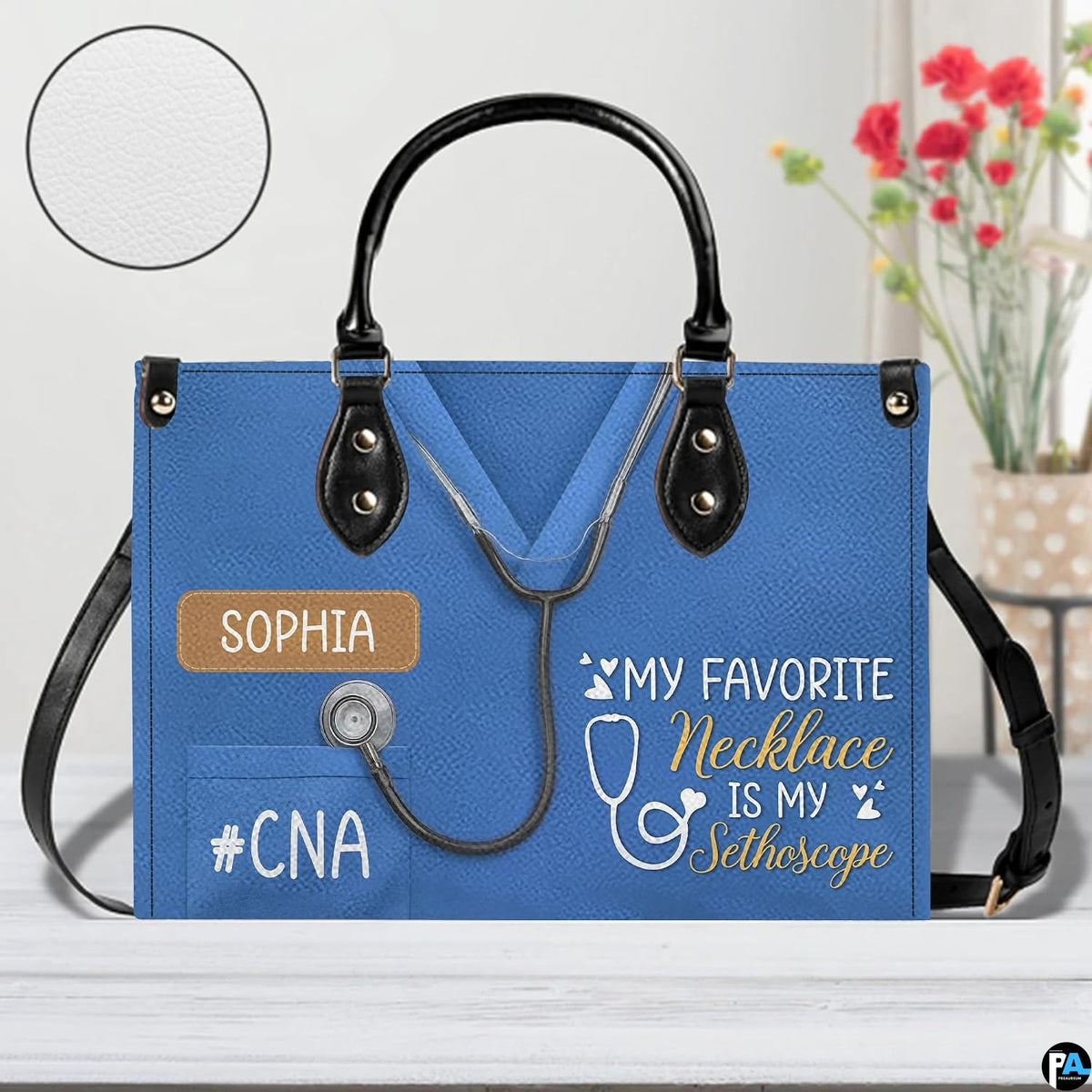 Angled perspective showing blue scrub uniform artwork on structured handbag