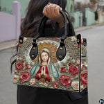 Street lifestyle view of woman carrying Our Lady of Guadalupe devotional handbag.
