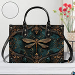 Bottom view of gold dragonfly handbag showing protective metal feet studs and smooth base wrap