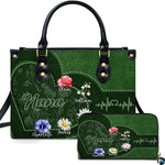 Emerald botanical heart handbag and matching zip wallet shown against studio background with floral artwork.