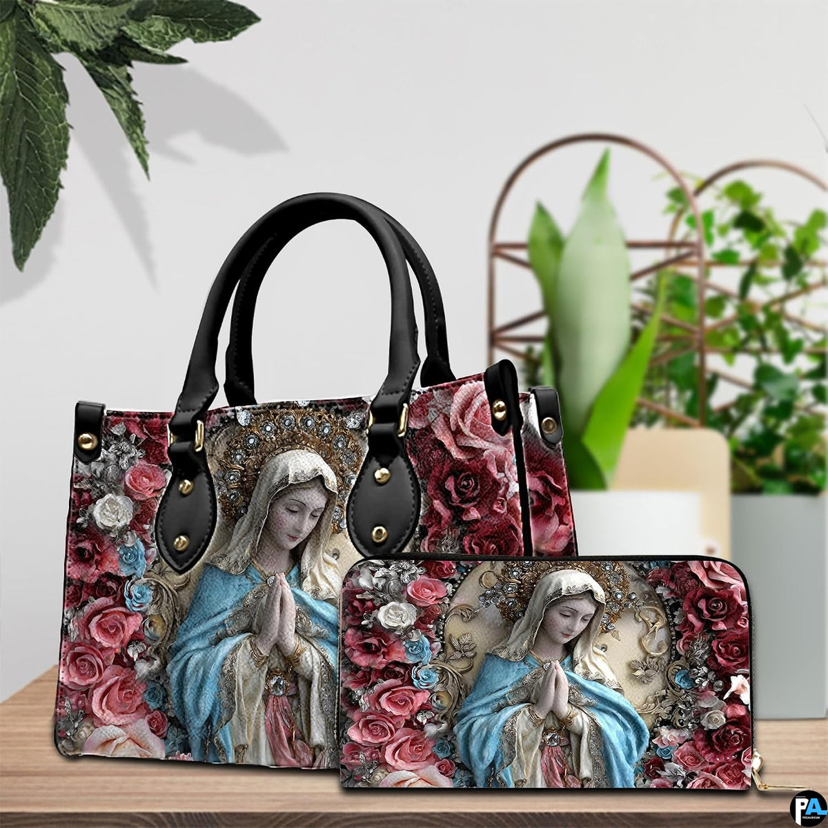 Pair arrangement of the praying Virgin Mary floral print set beside indoor green foliage.
