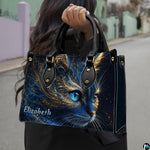 Outdoor perspective showing cosmic blue cat artwork held over arm by pedestrian along city sidewalk.