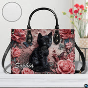 Studio presentation of sculpted black kitten and dusty pink rose artwork.