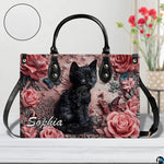 Studio presentation of sculpted black kitten and dusty pink rose artwork.