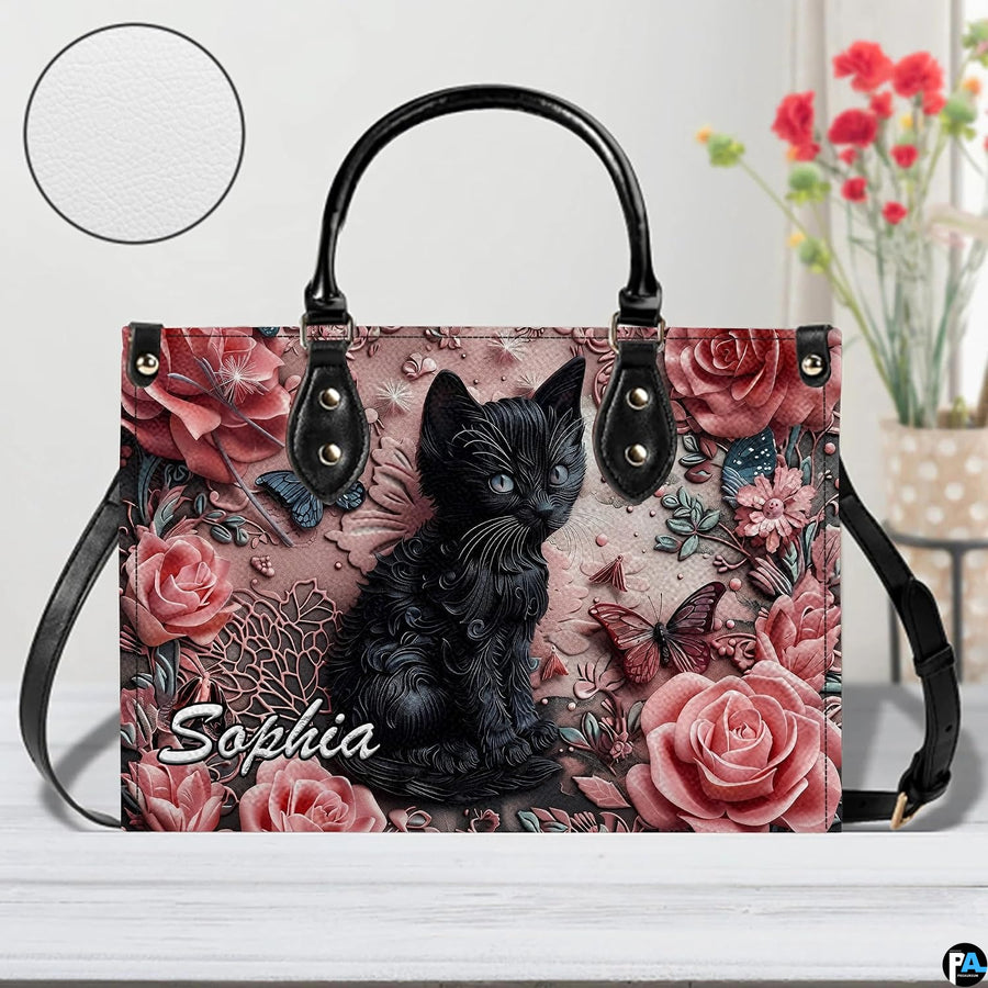 Studio presentation of sculpted black kitten and dusty pink rose artwork.