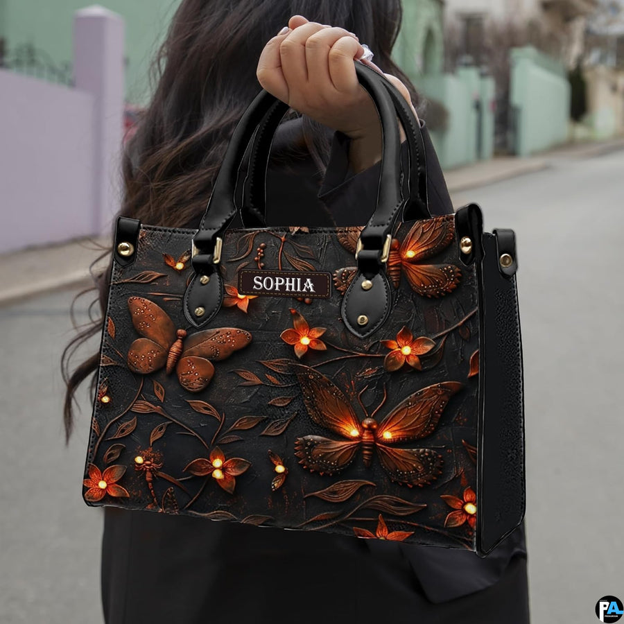 Outdoor street view of a model carrying the glowing insect handbag by its top handles.