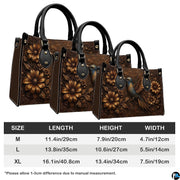 Rear view of bronze botanical handbag showing structured paneling on clean white background.
