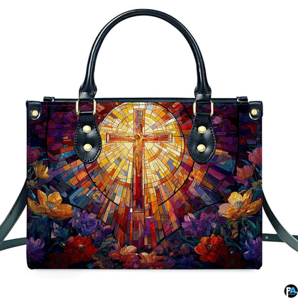 Front view of stained glass crucifix handbag standing upright on clean white background.