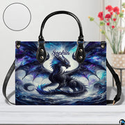 Front view of cosmic dragon handbag on white tabletop with circular textured exterior swatch.
