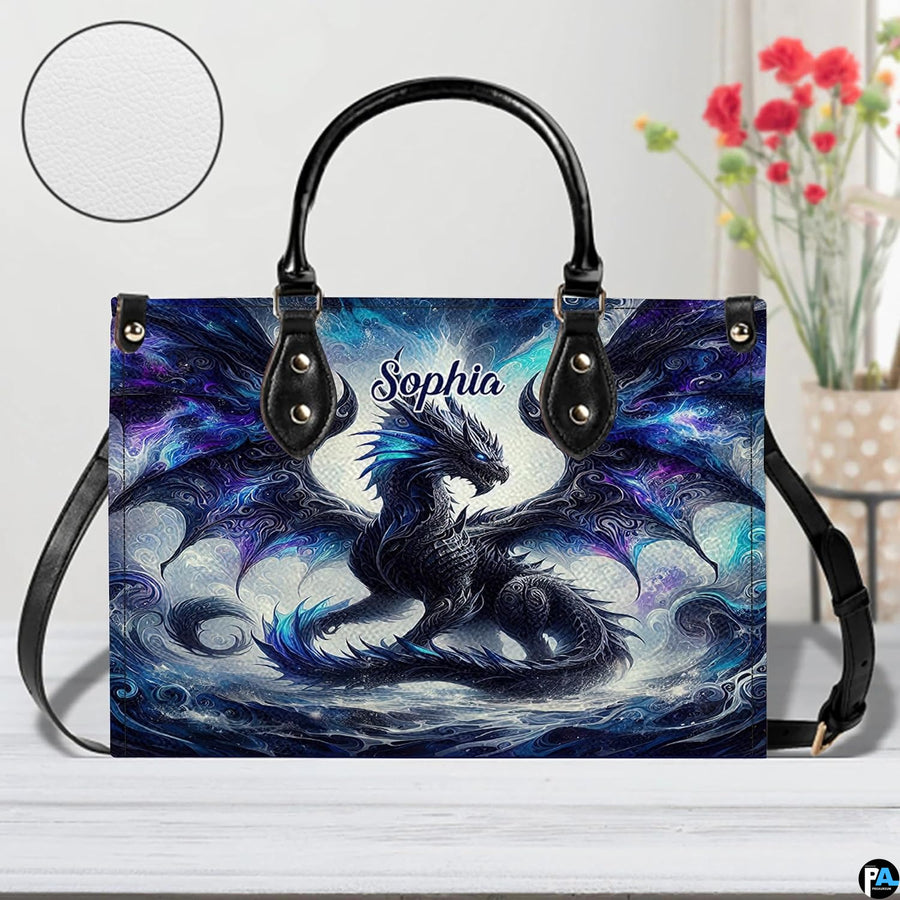 Front view of cosmic dragon handbag on white tabletop with circular textured exterior swatch.