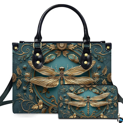 Studio display of embossed gold dragonfly handbag and matching wallet with botanical wreath on teal