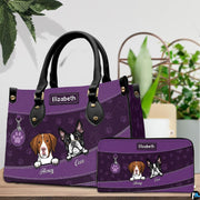 Angled view of purple canine purse displayed alongside matching zippered wallet companion.