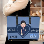 Model carrying Denim Blue Clinician Tote Handbag over shoulder in a modern indoor room.
