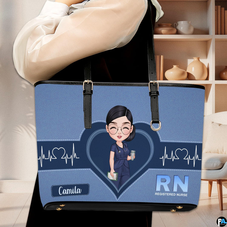 Model carrying Denim Blue Clinician Tote Handbag over shoulder in a modern indoor room.