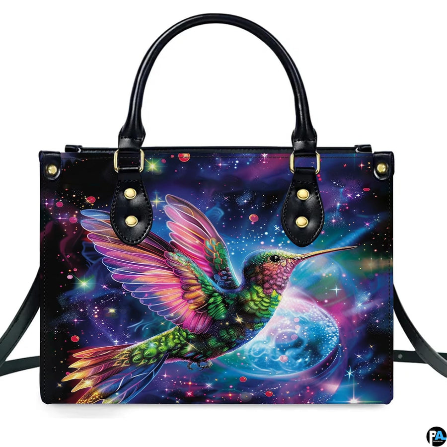 Studio front shot of cosmic hummingbird handbag against white studio background.
