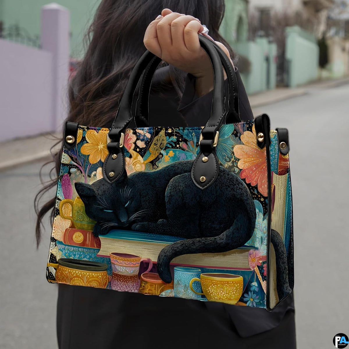 Sleeping black cat painting held outdoors along a sunny city street.