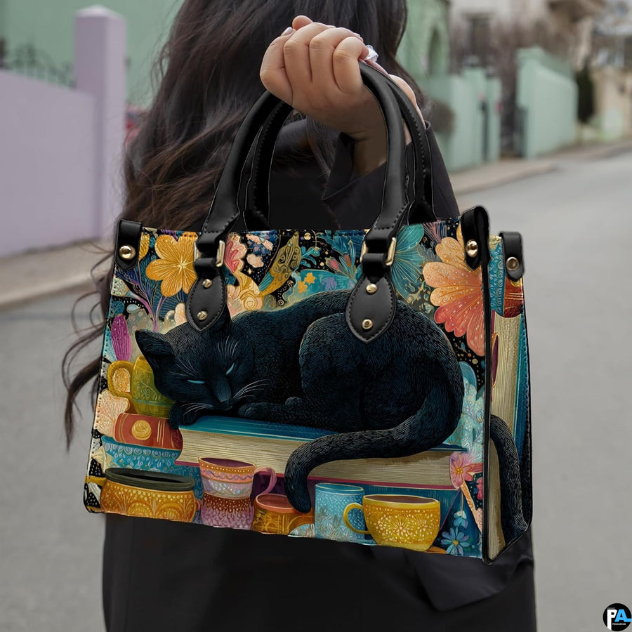 Sleeping black cat painting held outdoors along a sunny city street.