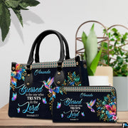 Hummingbird hibiscus handbag and wallet displayed on wooden table beside potted plant.