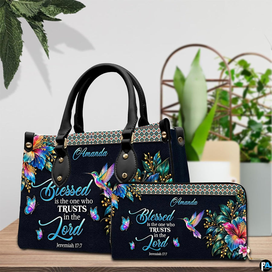 Hummingbird hibiscus handbag and wallet displayed on wooden table beside potted plant.