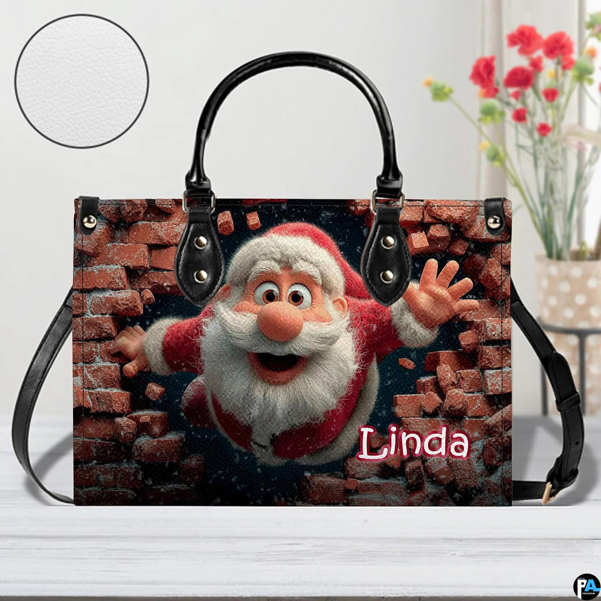Holiday Santa themed handbag displayed on white surface beside floral arrangement.